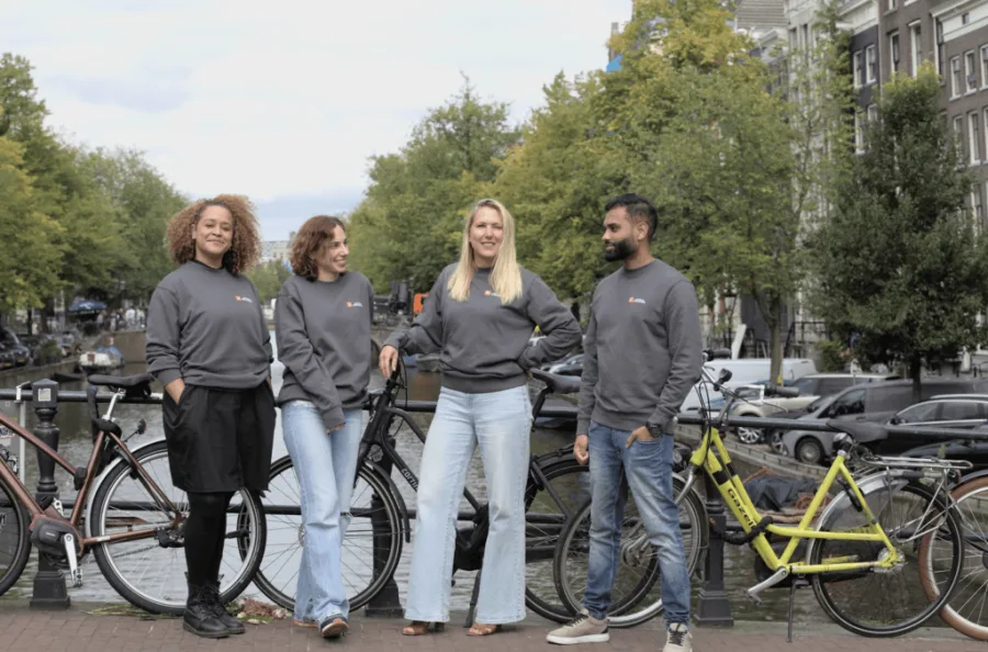 Amsterdam Data Academy students with their bikes along an Amsterdam canal